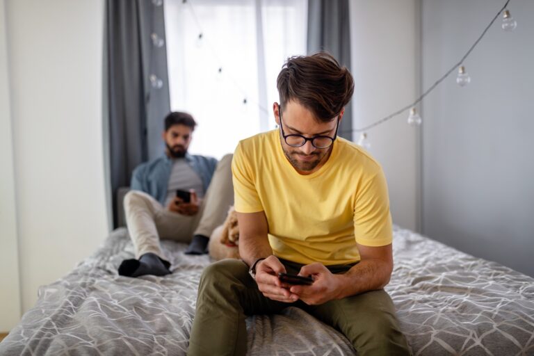 Sad homosexual gay couple arguing in bedroom at home