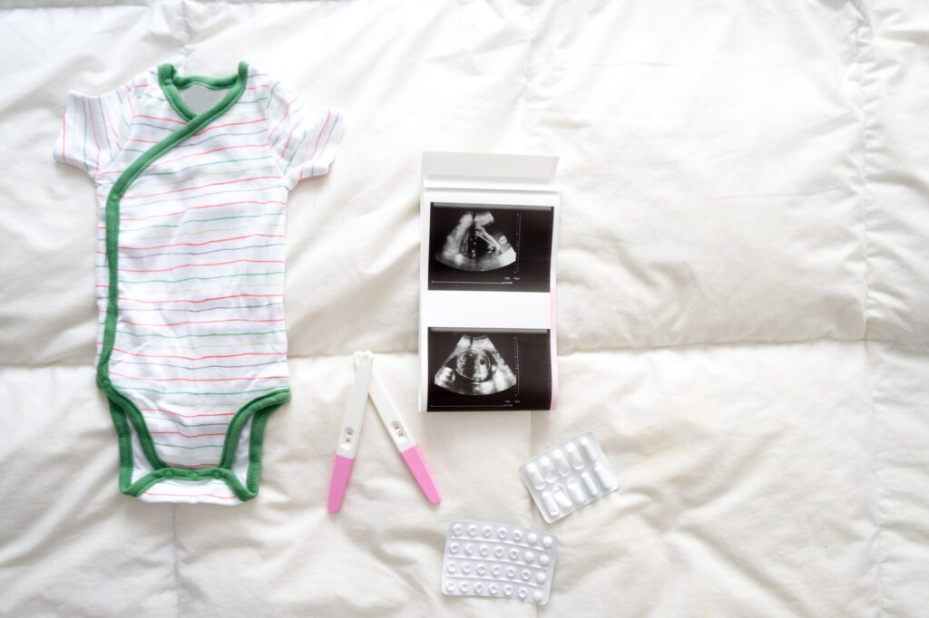 Pregnancy tests, baby clothes, pills and ultrasound scan on the