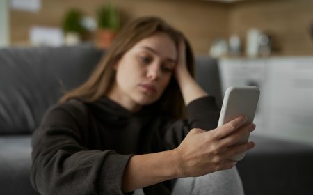 Caucasian nervous woman looking at mobile phone with sad face Caucasian nervous woman looking at mobile phone with sad face